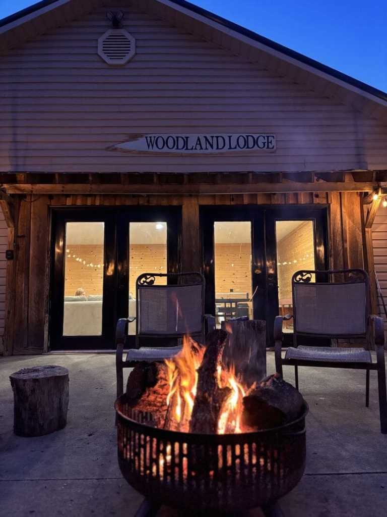 Photo of the outdoors of Woodland Lodge with a cozy fire pit.